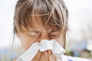 Young blonde female blowing her nose