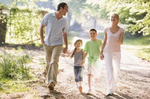 Family running outdoors holding hands and smiling