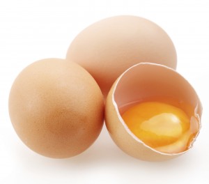 With brown eggs on a white background. One egg is broken.